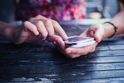 A,Young,Woman,Is,Using,Her,Smart,Phone,At,A